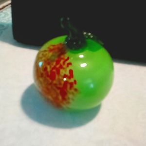 Light green glass apple with one leaf.Light brown specks on one side.